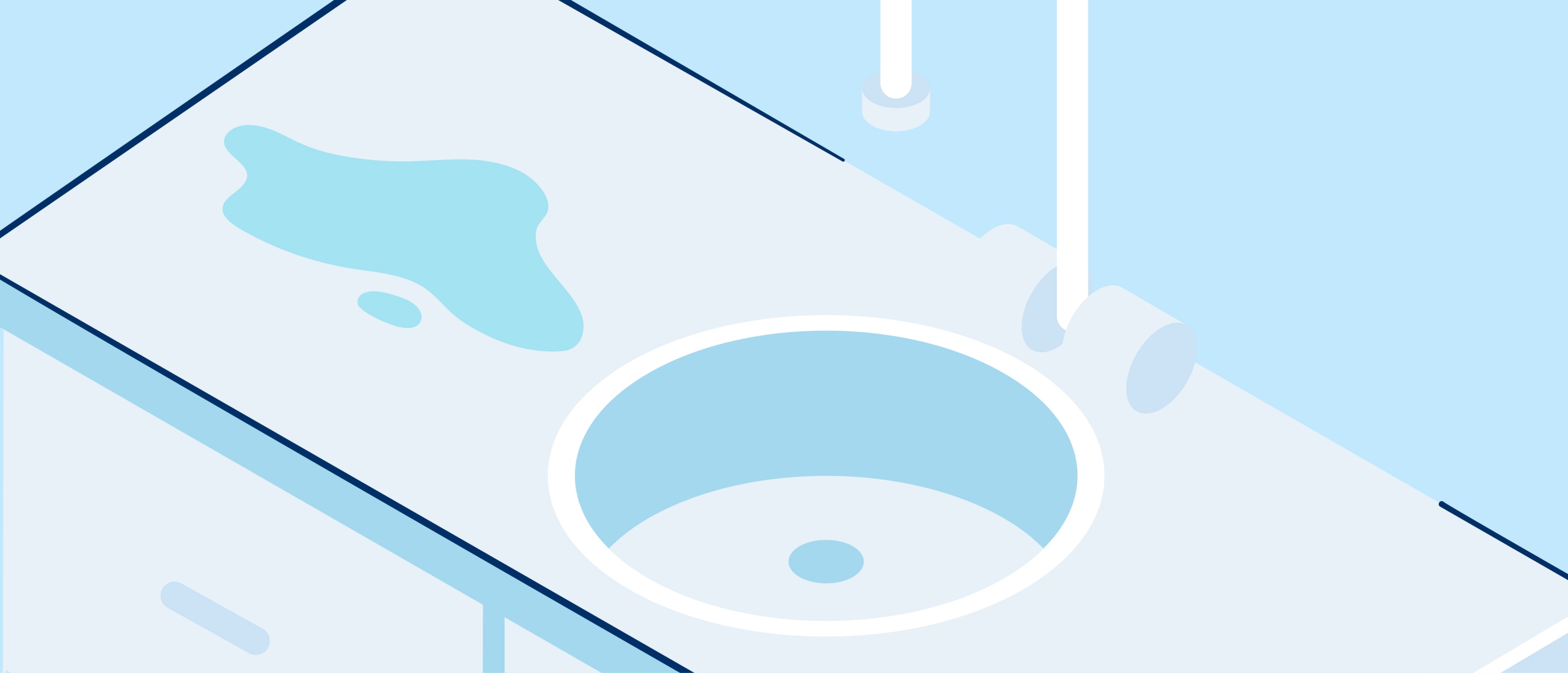 Top-down view of a pale-blue countertop with a round sink and a small puddle of water beside the basin.