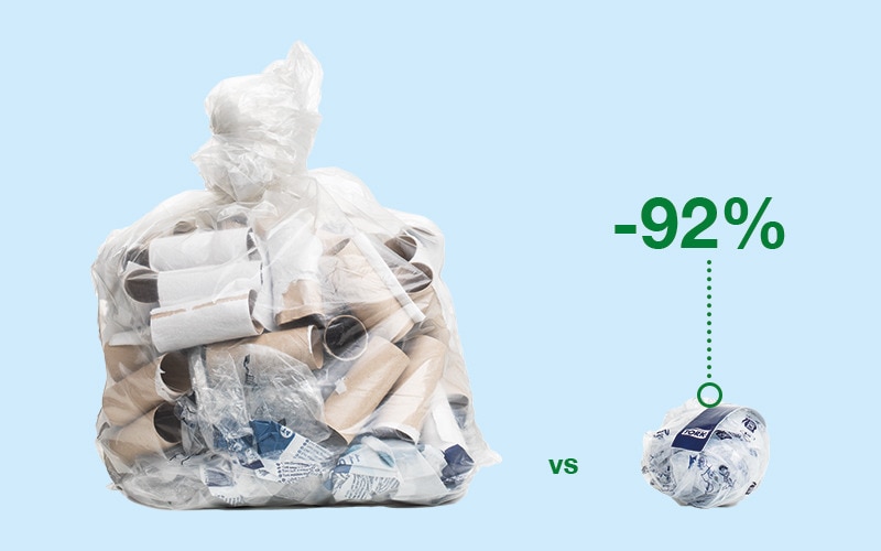 Plastic bag filled with toilet paper rolls. A label on the bin indicates that 92% of these items can be recycled.