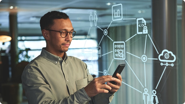 A facility manager using a smartphone with digital network and data icons displayed in the background 