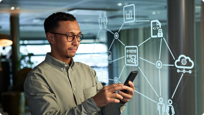A facility manager using a smartphone with digital network and data icons displayed in the background A facility manager using a smartphone with digital network and data icons displayed in the background