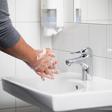 Close up of a person washing hands with soap