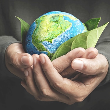 Close up of two hands holding a miniature of the earth