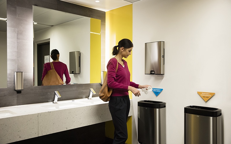 Une femme s'essuyant les mains dans les toilettes publiques