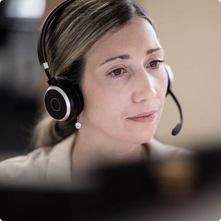 Customer service agent wearing a headset and speaking during a call Customer service agent wearing a headset and speaking during a call