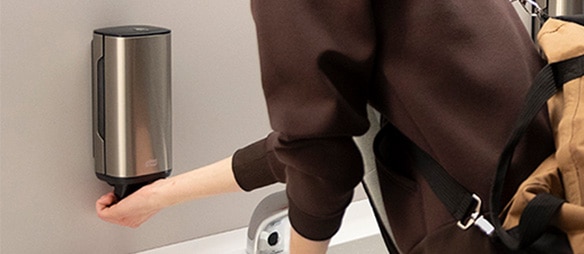 Student washing hands and dispensing soap