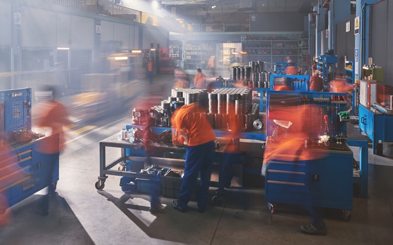 Tork, a timelapse image shows factory workers in a busy, industrial setting