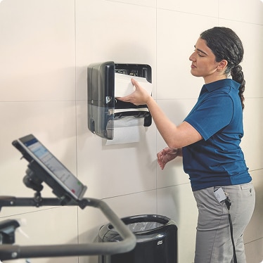Cleaner adding a new paper hand towel bundle in an IoT connected Tork dispensers Cleaner adding a new paper hand towel bundle in an IoT connected Tork dispensers