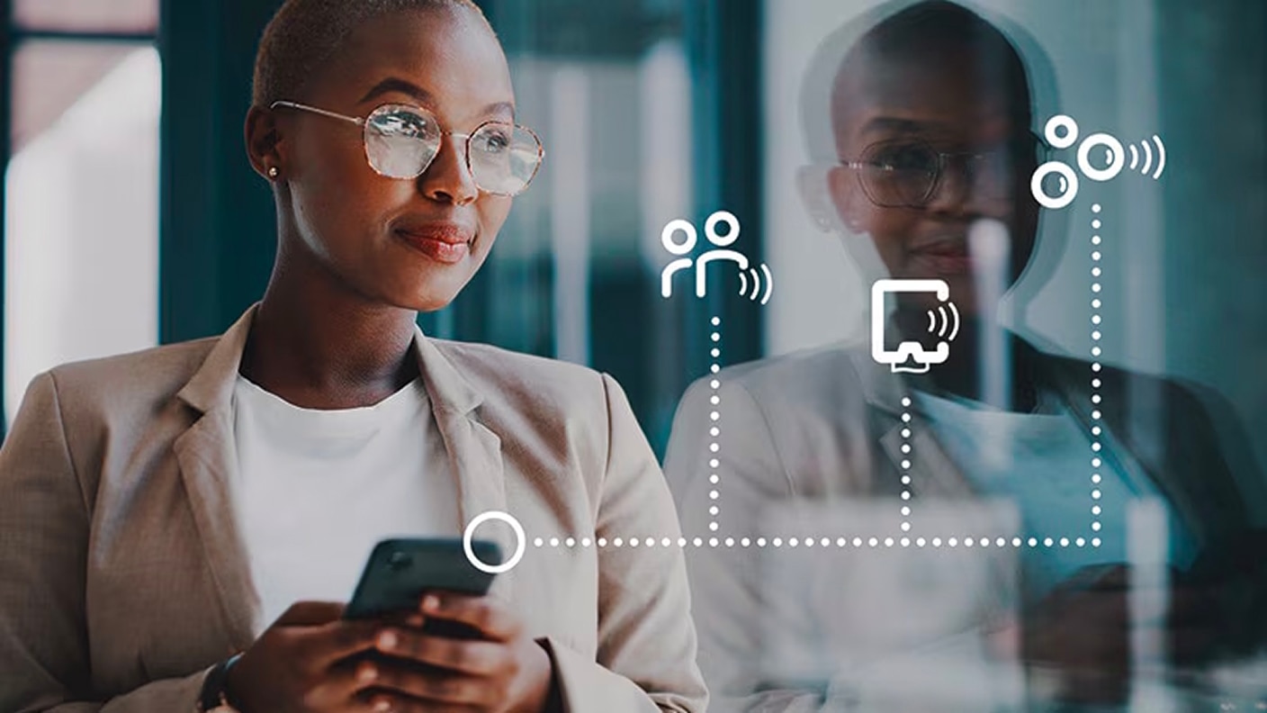 A facility manager using a smartphone with digital communication icons overlaid A facility manager using a smartphone with digital communication icons overlaid