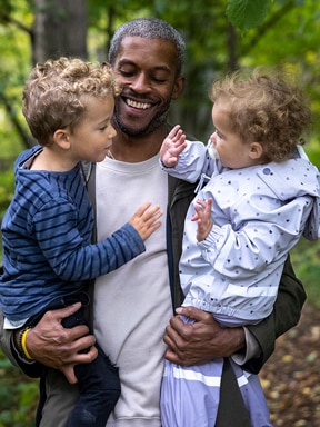 Close up of a man holding two kids in his arms