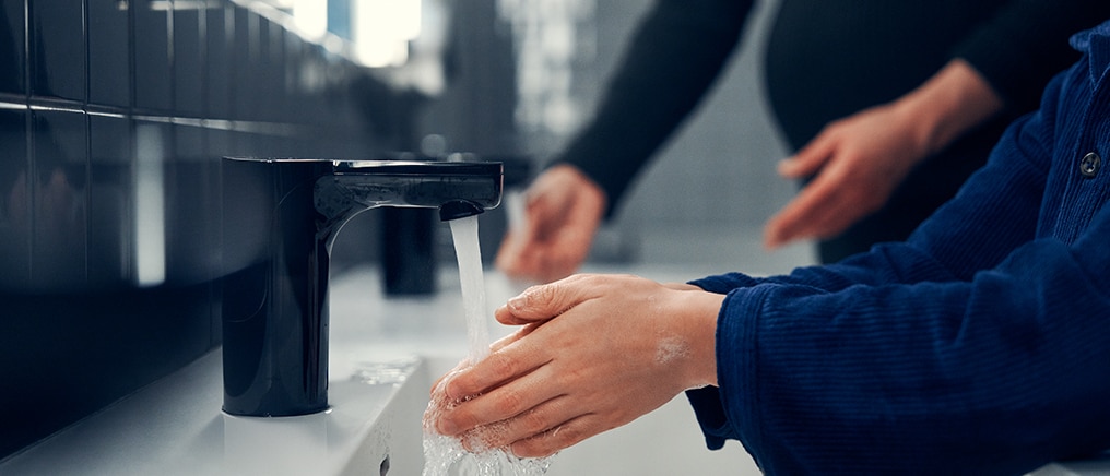 a person washing their hands with soap under running water 