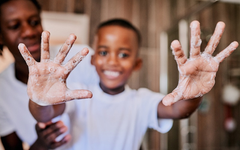Un băiat arătându-și mâinile curate