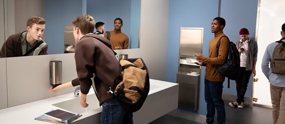 People washing and drying their hands in a modern washroom