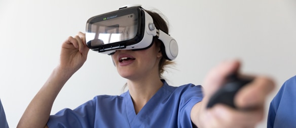 Een zorgprofessional gebruikt een VR‑headset en controller voor handhygiënetraining