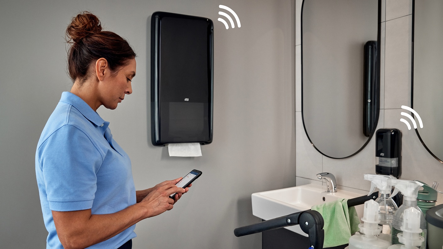 Cleaner in restroom checking dispenser refills