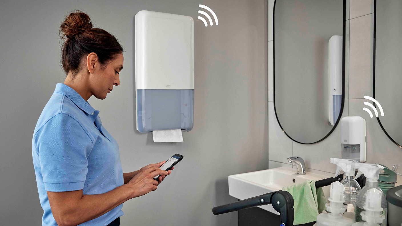 Cleaner in washroom checking dispenser refills