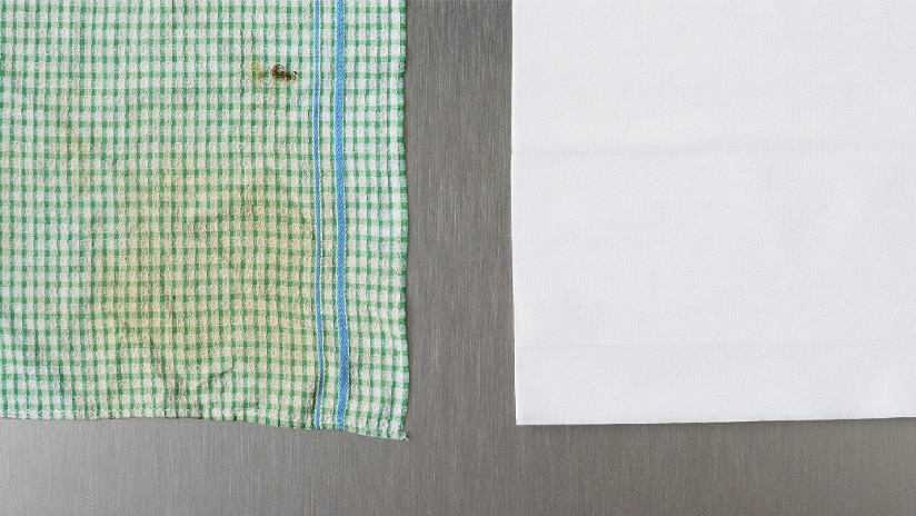 Dirty tea towel next to clean Tork Heavy-Duty Cleaning Cloth