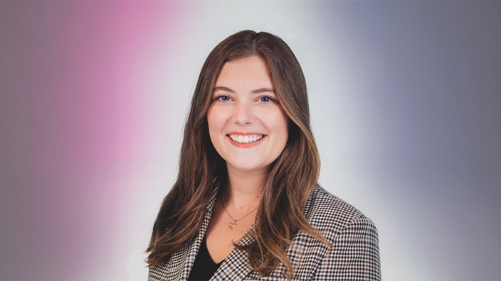 Headshot of a young woman smiling in a professional setting