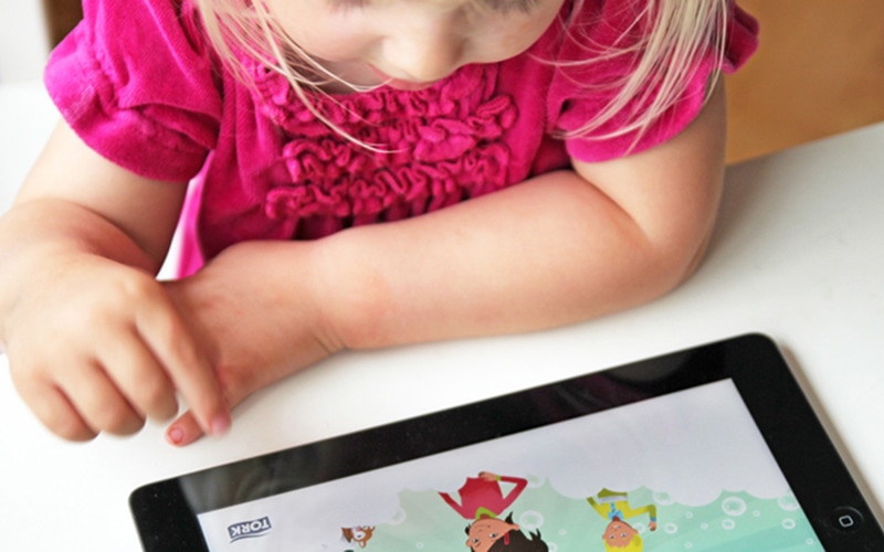 A little girl playing a game on a tablet