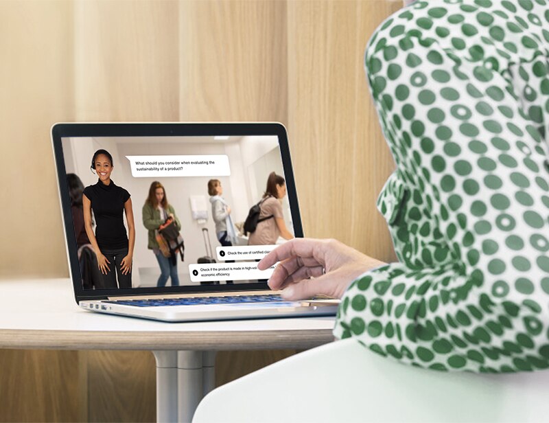 Ein Laptop-Bildschirm, eine Frau, die auf ihrem Laptop schreibt, und ein Text auf dem Bild, der besagt: "Informieren Sie sich über Nachhaltigkeit"