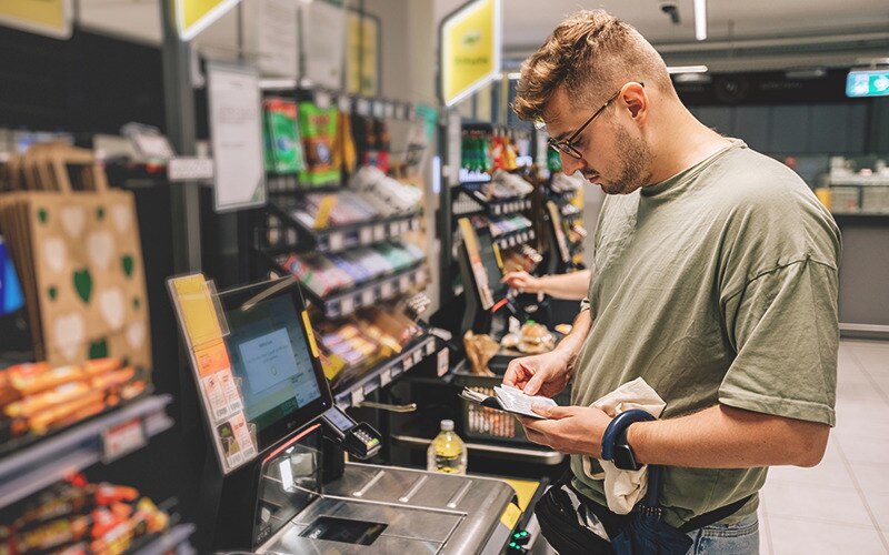 A man standing in front of a checkout register