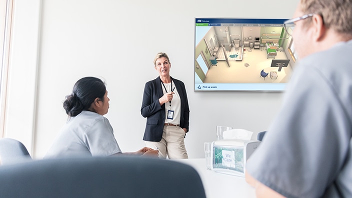 A trainer trains a nurse in the importance of surface cleaning in a hospital