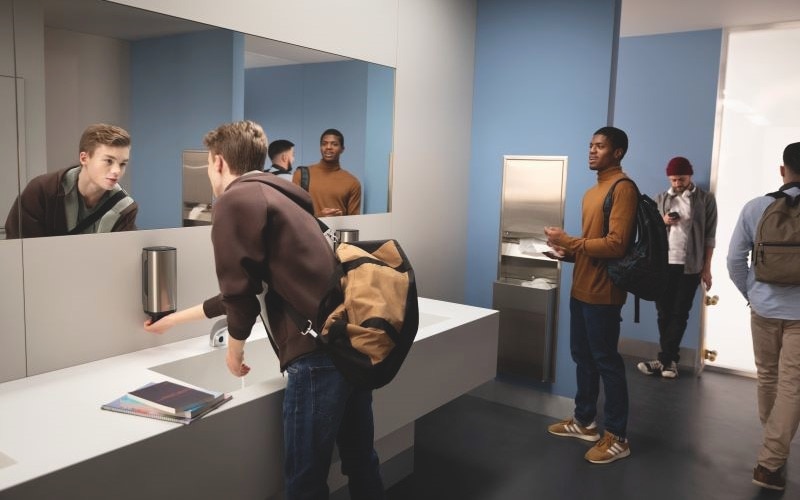 Personnes qui se lavent et sèchent les mains dans une salle de bains moderne.