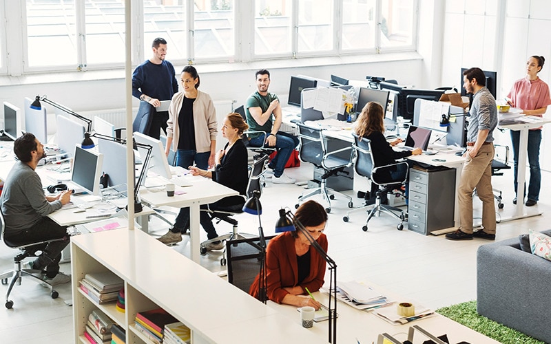 Birou tip spațiu deschis cu mai mulți angajați care împart același spațiu