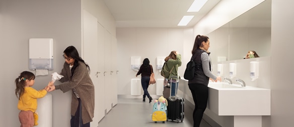 Ein moderner Sanitärraum mit mehreren Personen, die Hände waschen oder ein Kind beim Abtrocknen unterstützen.