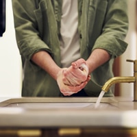 Hands being washed with soap under running water. Hands being washed with soap under running water.