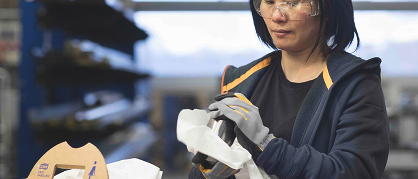 Woman polishing a part with a Tork polishing cloth