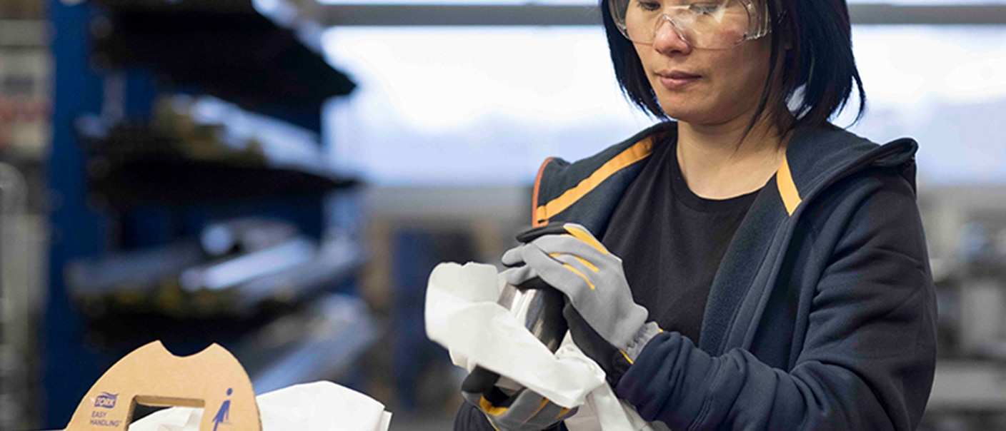 Woman polishing a part with a Tork polishing cloth