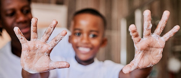 Enfant aux mains couvertes de mousse de savon