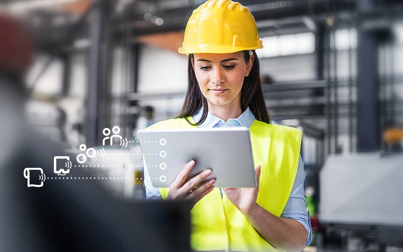 Women wearing hard hat looking at a tablet showing the Tork Vision Cleaning interface