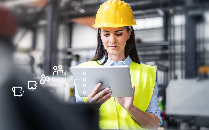 Women wearing hard hat looking at a tablet showing the Tork Vision Cleaning interface