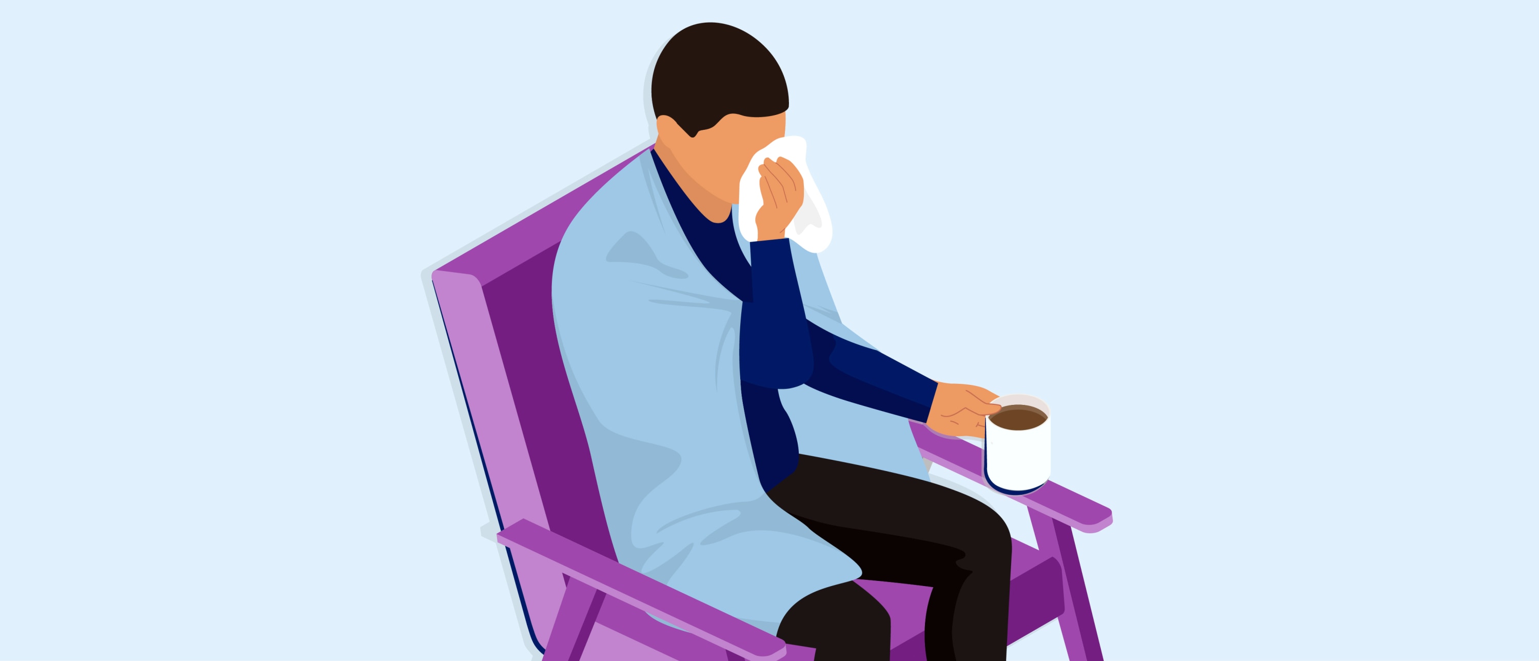 Person wrapped in a blanket, sitting in a purple chair, holding a tissue to their face and a mug in the other hand.